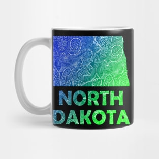 Colorful mandala art map of North Dakota with text in blue and green Mug